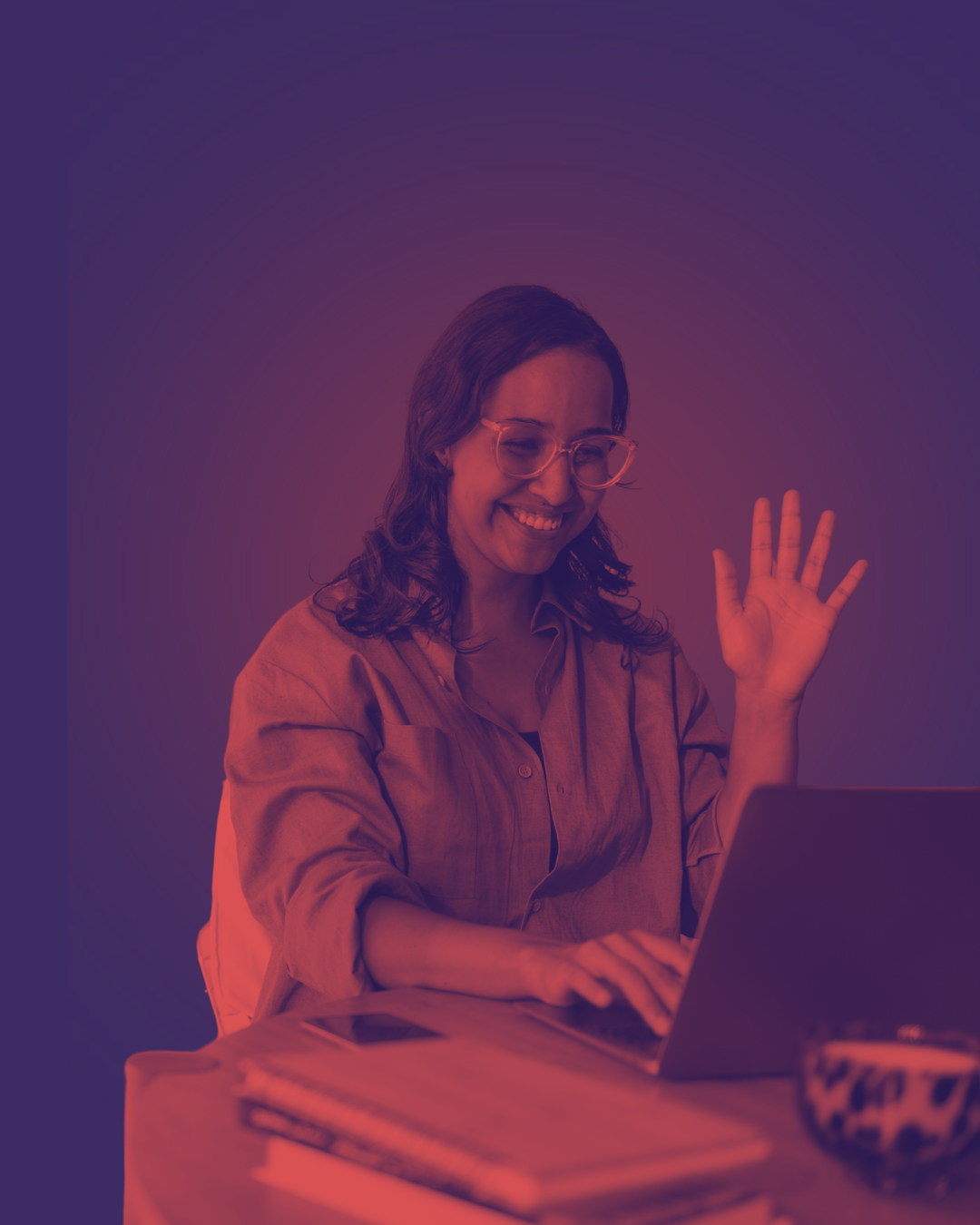 Mulher sorrindo e acenando durante sessão de terapia online no laptop